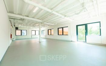 Spacious office interior at Lange Kleiweg 50-62 in Rijswijk, offering ample natural light through large windows, ideal for office space rental.