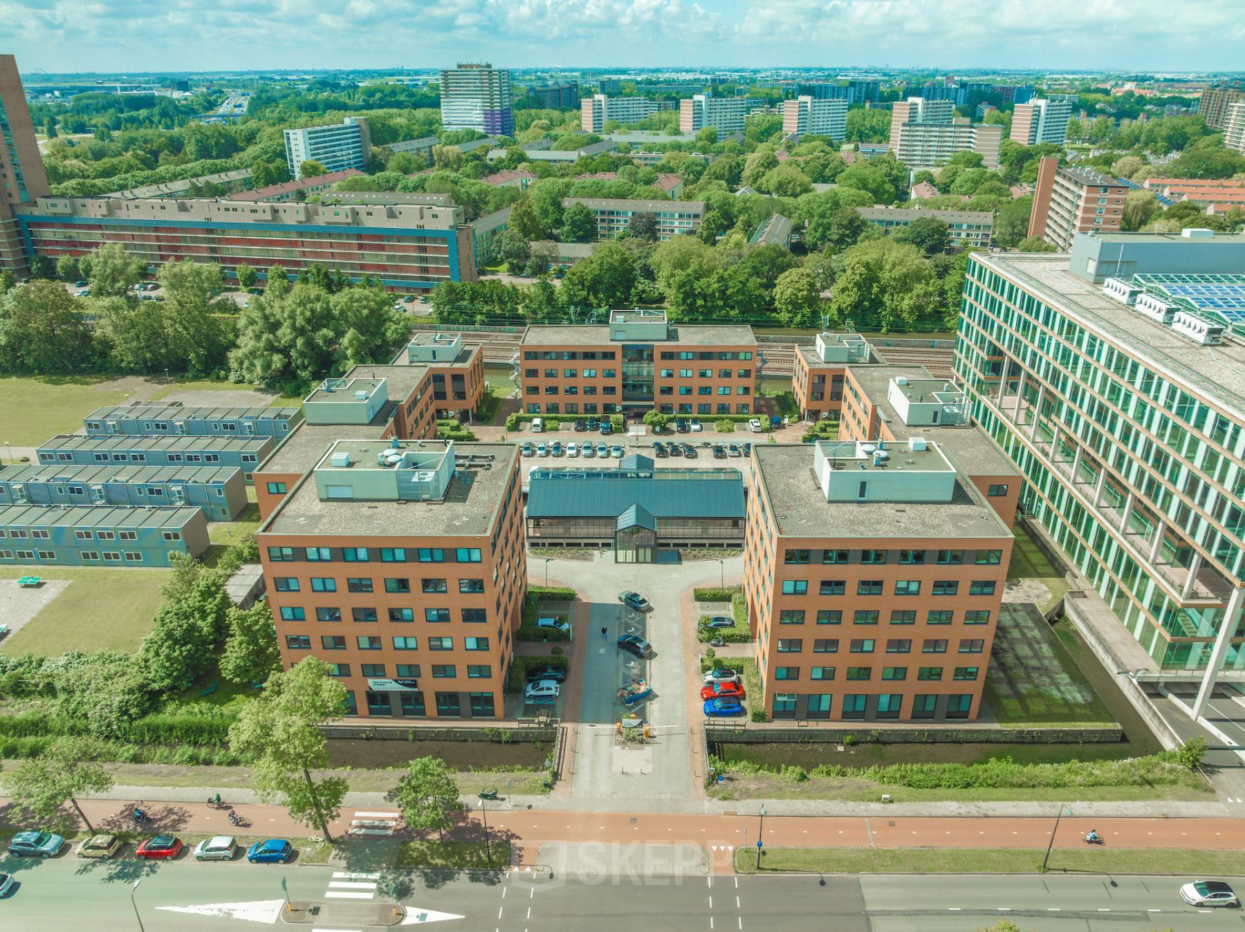 Aerial view of office buildings with a central courtyard at Lange Kleiweg 50-62, Rijswijk, surrounded by greenery and urban landscape, highlighting opportunities for office space rental.