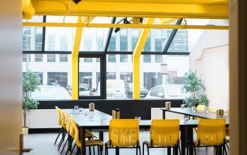 Bright office space with yellow ceiling and large windows at Volmerlaan 7, Rijswijk, available for rent. Suitable for meetings and collaboration.