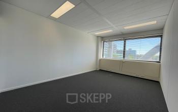 Empty office space with large windows overlooking cityscape at Generaal Eisenhowerplein 111 111, Rijswijk. Ideal for office space rental, featuring bright natural light and neutral decor.
