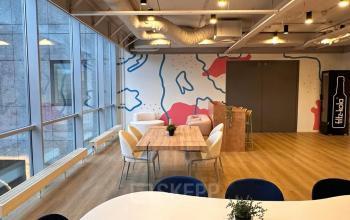Bright office space with modern furnishings, featuring large windows and abstract wall art at Generaal Eisenhowerplein 111, ideal for businesses seeking a dynamic environment.