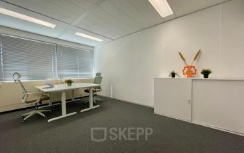 Bright and modern workspace interior at Generaal Eisenhowerplein 111 111, Rijswijk, with white furniture and large windows. Ideal office space rental option for small teams, featuring sleek tables and chairs.
