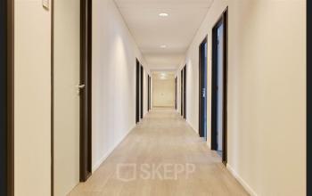 Office hallway at Patrijsweg 62, Rijswijk, featuring a series of doors leading to various office spaces. Ideal for office space rental.
