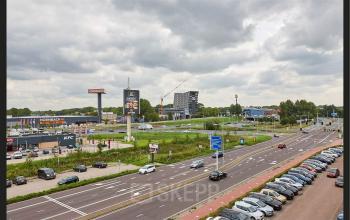 Exterior view near Patrijsweg 62 in Rijswijk, showcasing nearby businesses and ample parking space, ideal for those exploring office space rental options.