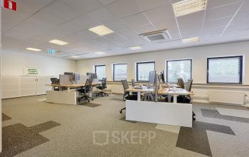 Office space at Patrijsweg 62, Rijswijk, featuring rows of desks and chairs under a grid ceiling, ideal for office space rental.