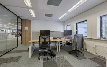 Interior view of a furnished office space with workstations at Patrijsweg 62, ideal for rent office space in Rijswijk. Equipped with desks, chairs, and computers, ready for business activities.