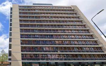 Exterior view of a multi-story office building at JC van Markenlaan 3, Rijswijk. The building has large windows and is suitable for office space rental. Several parked cars are visible in front.