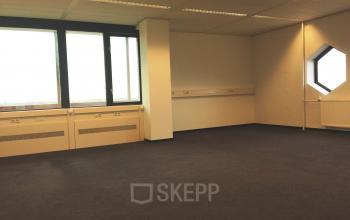 Spacious office available for rent at JC van Markenlaan 3, Rijswijk, featuring large windows and carpeting. Ideal for office space rental.