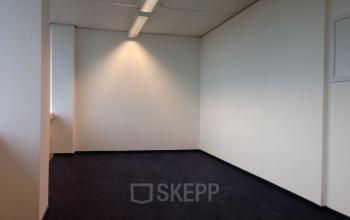 Minimalist office space at JC van Markenlaan 3, Rijswijk, available for rent. The room features a neutral palette and ample lighting, ideal for office space rental.