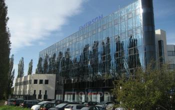 Exterior of office building at Patrijsweg 4-140 in Rijswijk, featuring a modern glass facade and a parking lot in front.