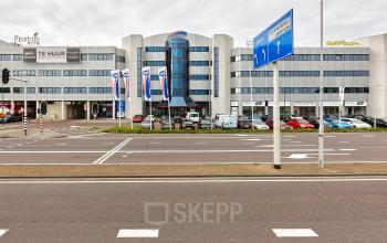Exterior view of the office building at Patrijsweg 4-140, Rijswijk, featuring surrounding roads and parked cars, suitable for office space rental.