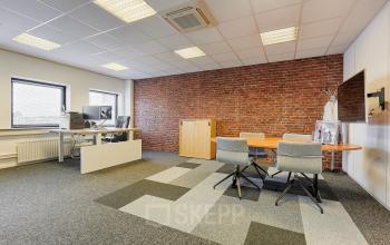 Modern office space with brick accent wall, carpeted flooring, desks, chairs, and large windows at Patrijsweg 4-140, Rijswijk.