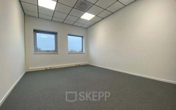 Minimalist office to rent at Noordhoven 19, Roermond, with clean lines and ample natural light from large windows, providing a neutral space for business activities.