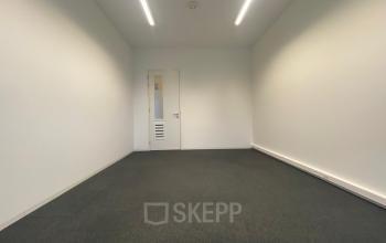 Empty office space at Boven de Wolfskuil 3, Roermond, with grey carpet and white walls, offering a minimalist environment ideal for rent office space.