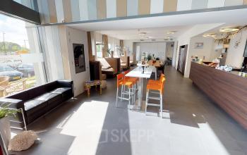 Modern and bright office space for rent in Roermond at Boven de Wolfskuil 3, featuring a furnished lounge area with stylish seating and a contemporary open floor plan.