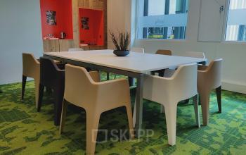 Spacious, furnished office space available for rent at Boven de Wolfskuil 3, Roermond, featuring a modern table and chairs, ideal for meetings.