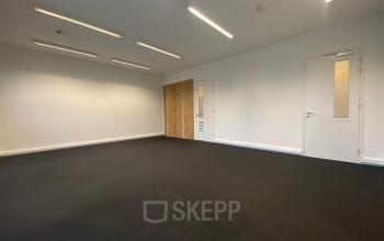 Spacious office space with minimal furnishings at Boven de Wolfskuil 3, Roermond, available for rent. The room has bright lighting and neutral walls, ideal for office space rental.