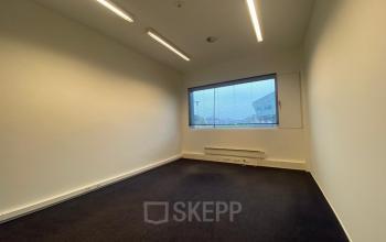 Unfurnished office space for rent at Boven de Wolfskuil 3, Roermond, featuring a spacious layout and ample natural light from a large window.