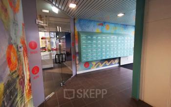 Modern entrance corridor at Corkstraat 46 office space rental in Rotterdam Airport with bright artwork and mailboxes.