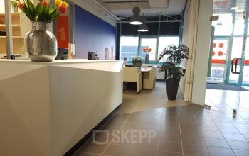 Bright office space rental at Corkstraat 46, Rotterdam Airport, featuring a stylish reception area with tulips and modern furnishings.