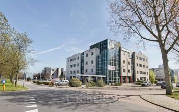 Modern office space rental at Corkstraat 46, set against a bright blue sky in Rotterdam Airport, with ample parking available.