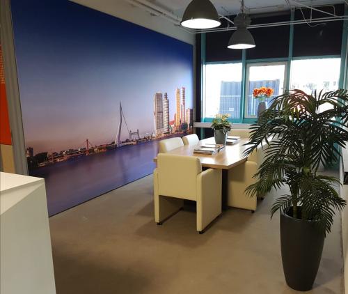 Modern office space rental at Corkstraat 46, Rotterdam Airport, featuring a vibrant cityscape mural and stylish furnishings.