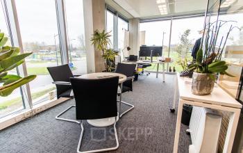 Furnished office space rental at Rotterdam Airport with large windows and modern decor, perfect for businesses seeking an office to rent.