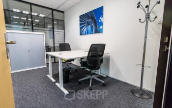 Modern office space available for rent at Rotterdam Airportplein 22, featuring a sleek design with office desks, chairs, and a coat stand. Ideal for professional activities in Rotterdam Airport.