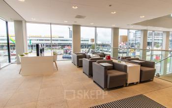 Modern office space with a view, featuring comfortable seating and bright lighting, perfect for rent office space near Rotterdam Airport.