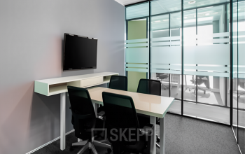 Modern office space to rent at Rotterdam Airportplein 22, featuring a meeting room with a conference table and chairs, ready for office space rental.