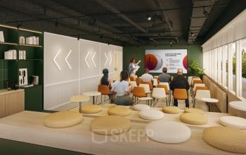 Modern furnished office space for rent in Rotterdam Alexander, featuring a presentation area with attendees seated and a kitchenette.