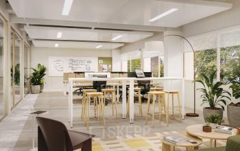 Bright office space in Rotterdam Alexander with modern furnishings, including a high table and stools, surrounded by large windows and greenery. Ideal for office space rental.