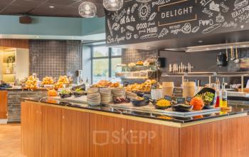 Inviting office pantry area with a buffet of food items, pumpkins, and decorative elements, ideal for a comfortable workspace experience.