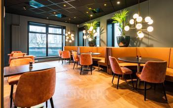 Stylish office space at Rotterdam Alexander with elegant seating and decor, ideal for rental. Large windows provide natural light.