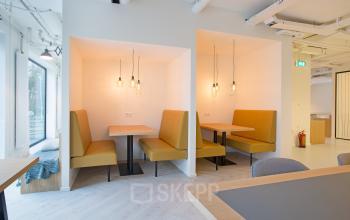 Modern furnished workspace with yellow bench seating and pendant lighting at office located at Marten Meesweg 8-10, Rotterdam Alexander.