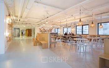 Open-plan workspace with modern furnishings located at Marten Meesweg 8-10, Rotterdam Alexander. Features ample seating, large windows, and stylish lighting, ideal for office to rent.