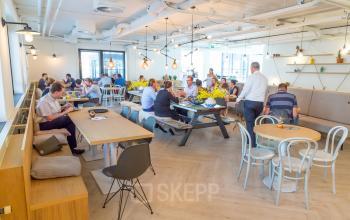 Modern office space with employees engaged in collaborative activities at Marten Meesweg 8-10, Rotterdam Alexander. Features open workspaces, contemporary furnishings, and ample natural light.