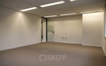Empty office space available for rent at Marten Meesweg 8-10, Rotterdam Alexander, featuring carpeted flooring and glass doors.