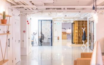 Modern office interior at Marten Meesweg 8-10, Rotterdam Alexander, featuring open walkways, shelving units, and glass-walled meeting rooms.