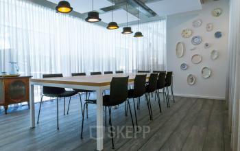 Conference room at Marten Meesweg 8-10, Rotterdam Alexander, featuring a long table with chairs, pendant lights, and wall decor.