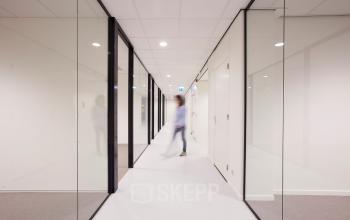Modern hallway at Marten Meesweg 8-10, Rotterdam Alexander, featuring glass walls and sleek design.