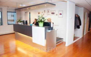 Reception area of an office at Hoofdweg 66, Rotterdam Alexander, featuring a modern desk and two employees working on computers.