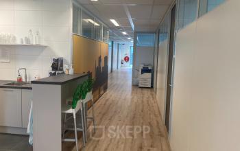 Interior hallway of an office space rental at Hoofdweg 66, Rotterdam Alexander, featuring a small kitchenette, modern decor, and bright lighting.