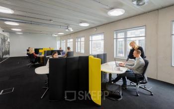 Professionals engaged in a discussion at a modern office space rental in Rotterdam Brainpark at Bahialaan 100.