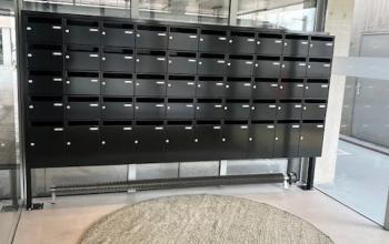 Lobby at Bahialaan 100, Rotterdam Brainpark with modern mailboxes and rugs, offering a sleek introduction to office space rental.