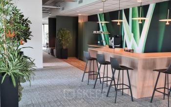 Modern office pantry at Bahialaan 100, Rotterdam Brainpark, featuring sleek bar stools, a coffee machine, and contemporary decor.