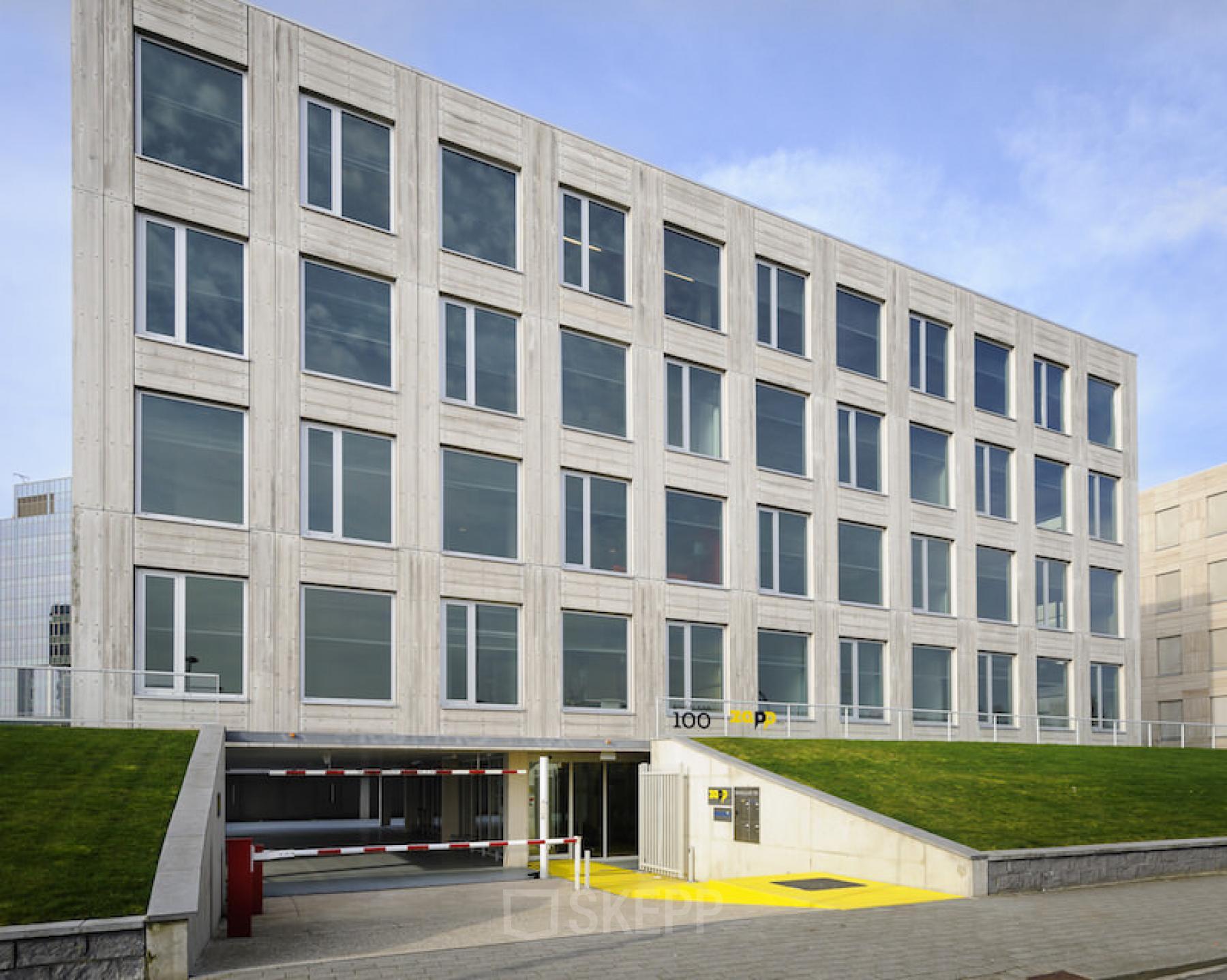 Modern facade of the office space rental at Bahialaan 100 in Rotterdam Brainpark, showing structured design and parking entrance.