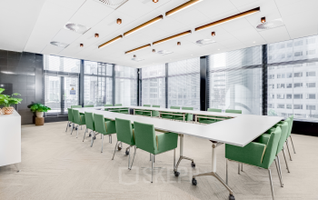 Spacious, well-lit conference room at Weena 505, Rotterdam Central Station with large windows and modern furnishings, ideal for office space rental.