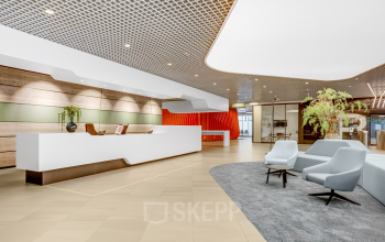 Bright, modern office reception area at Weena 505, Rotterdam Central Station, featuring stylish seating and a sleek desk for office space rental inquiries.