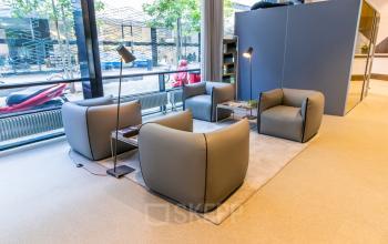Furnished lounge area at Weena 290, Rotterdam Central Station, perfect for office space rental with comfortable chairs and modern design.